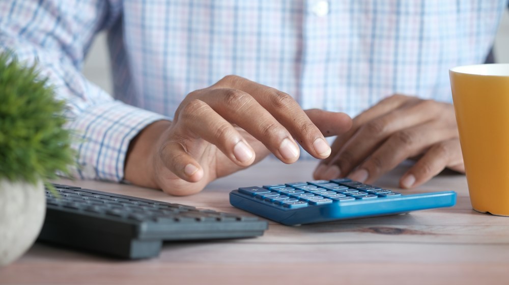 A calculator and notebook on a desk